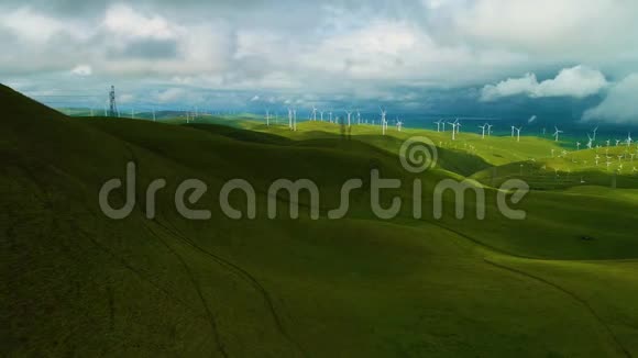 在日落时分空中飞行的可再生能源风力发电场关闭了一个风力涡轮机在农民的田野上旋转视频的预览图