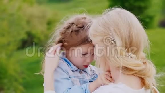 一个卷曲的金发女孩和她的母亲的肖像温柔关怀和母爱视频的预览图