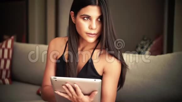 年轻女性通过使用平板电脑来选择娱乐视频的预览图