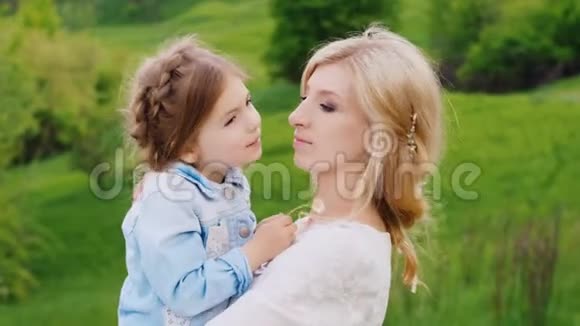 一位忧郁的年轻女子的肖像她挽着她的手臂温柔地拥抱着她的小女儿视频的预览图