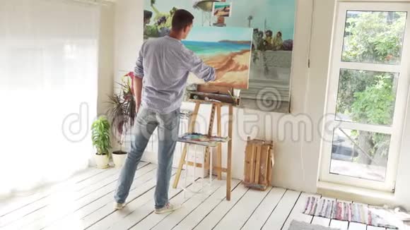男画家在画布上画风景视频的预览图