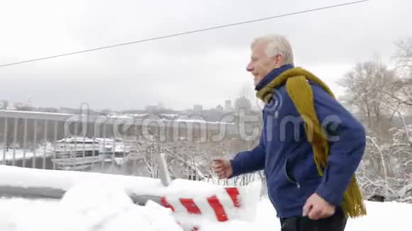 一个欧洲老人在雪道上跑过一个十字路口冬天运动有氧运动健康的生活理念60英尺视频的预览图