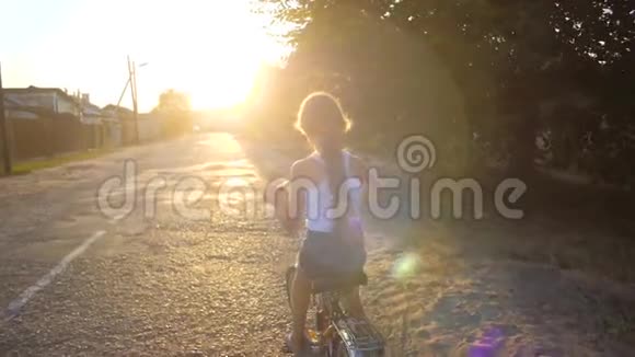 孩子骑着自行车在大街上慢动作视频的预览图