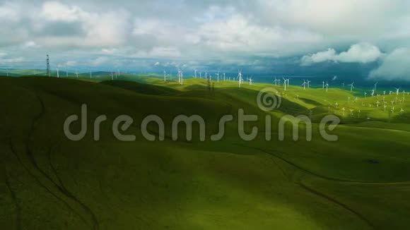 在日落时分空中飞行的可再生能源风力发电场关闭了一个风力涡轮机在农民的田野上旋转视频的预览图