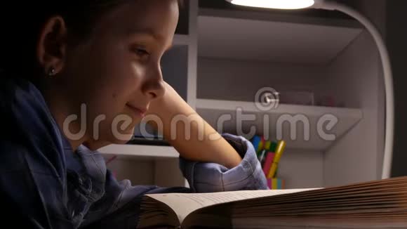 夜晚的孩子阅读黑暗的学校女孩孩子学习家庭作业视频的预览图