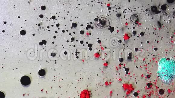 在液体滴油漆表面透明粘稠液体有墨滴和散落的油漆颗粒视频的预览图