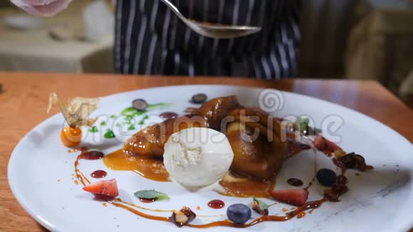 餐厅甜品烹饪理念最后的触摸概念厨师用手套将焦糖酱倒入带有冰淇淋和视频的预览图