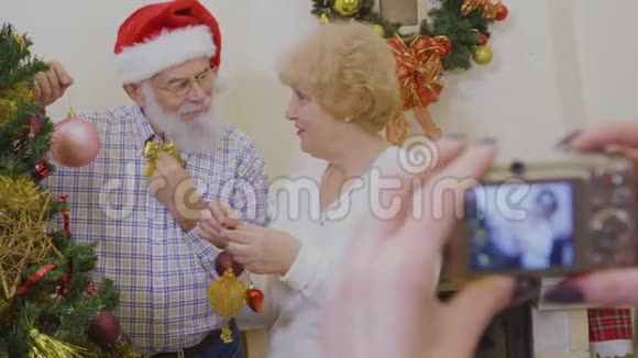幸福的老夫妇一起装饰圣诞树视频的预览图