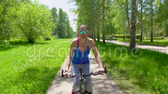 女人骑着一辆带智能手表心率监视器的自行车智能手表的概念快乐的年轻女子笑着笑着骑马视频的预览图