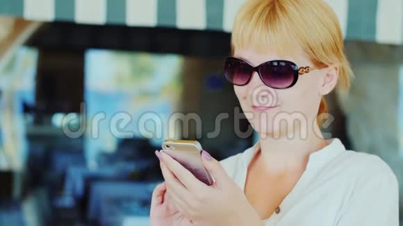 女游客在商店橱窗的背景下使用手机视频的预览图