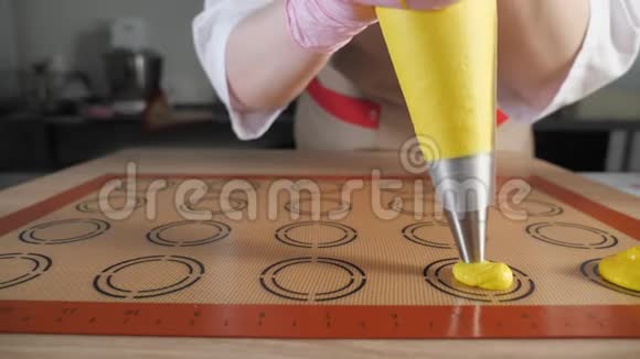糕点厨师正在烹饪马卡龙在模板硅胶垫上浇注面团视频的预览图