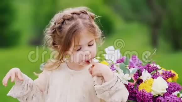 一个滑稽的傻姑娘坐在公园的一张桌子上用她的手吃一个甜蛋糕的巧克力的痕迹视频的预览图
