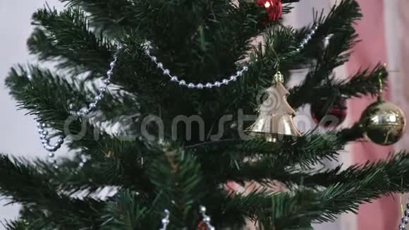 人工圣诞树树枝上的珠子和金色圣诞玩具视频的预览图