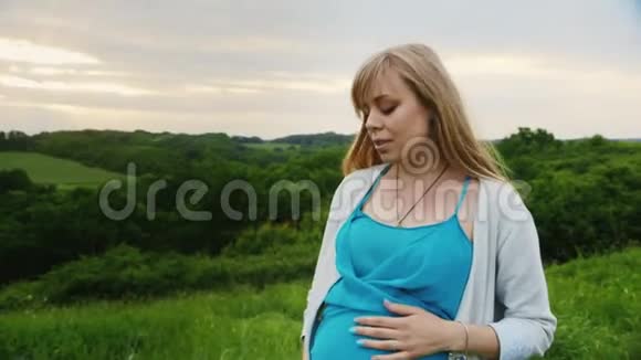 stadicam射击孕妇在绿色森林背景下的风景桥上行走视频的预览图