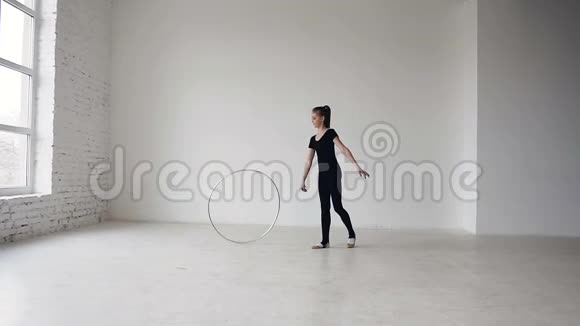 女孩用体操圈训练韵律体操金发女孩用箍棒训练体操视频的预览图