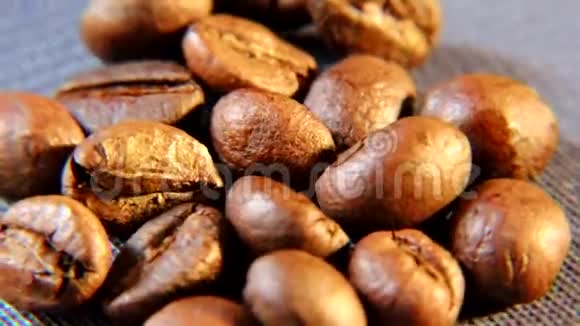 棕色的芳香咖啡颗粒在桌子上粗布的基材上旋转视频的预览图