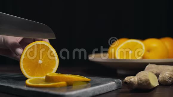 橘子是用锋利的刀在岩石板上切片新鲜的橘子切片水果和维生素素食制作视频的预览图