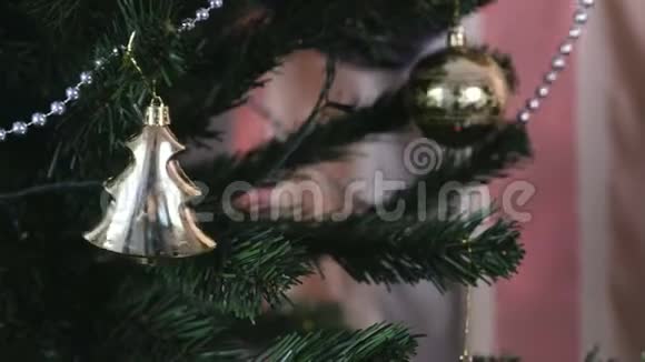 人工圣诞树树枝上的珠子和金色圣诞玩具视频的预览图