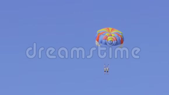 两个面目全非的人在一个彩色降落伞上飞行视频的预览图