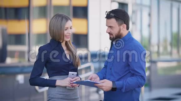 两位同事午休时在街上聊天穿着蓝色衬衫的男人拿着民意测验视频的预览图