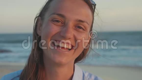 幸福的女人看着镜头慢镜头地笑着海滩的肖像视频的预览图