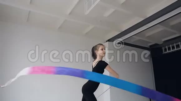 体操学校有魅力的女子体操运动员用彩带跳舞黑色身体中的纤纤维质视频的预览图