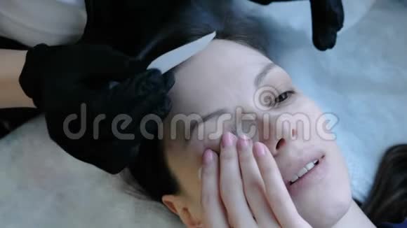 美容治疗美容师在女人的眼睛下面贴补丁上景视频的预览图