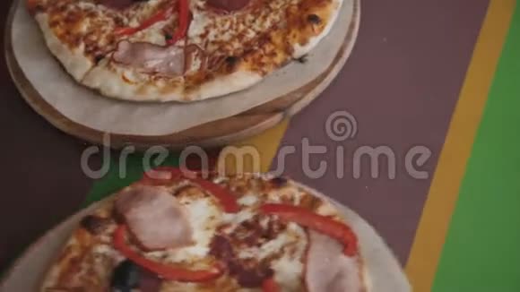 一个人用一个比萨饼切割器把一个美味的比萨饼切成片的俯视图4K视频的预览图