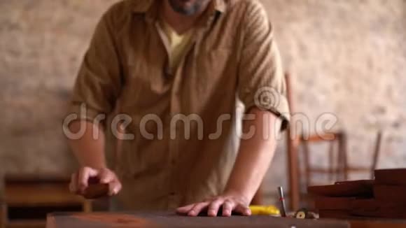 英俊的木匠用木头工作视频的预览图