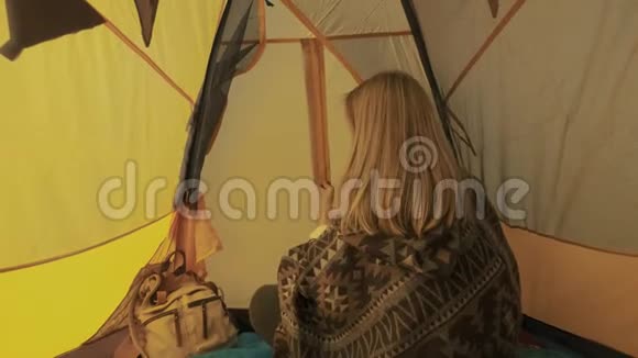 年轻女子打开帐篷入口女孩从帐篷里偷看出来在大自然中露营乡村之旅一种好奇视频的预览图