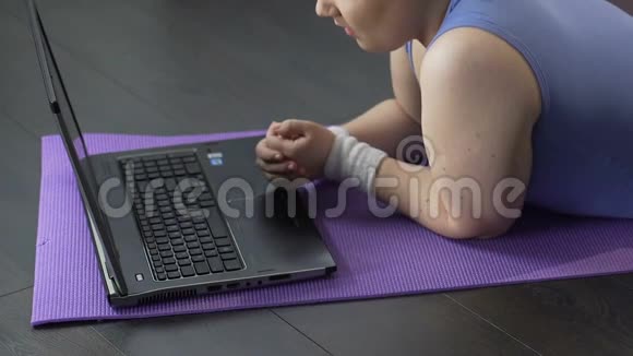 超重女孩躺在笔记本电脑前愤怒地打字反馈意见视频的预览图