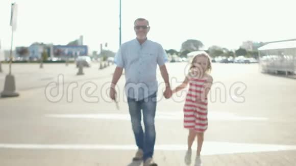 一个成年男子和一个卷发女孩从停车场到超市父女父日家庭视频的预览图