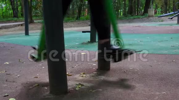 十几岁的女孩在一个模拟器上工作夏天在公园里练习健身慢动作视频的预览图