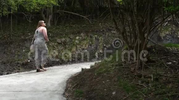 白种人女性走在刚加固的山上穿过树木视频的预览图