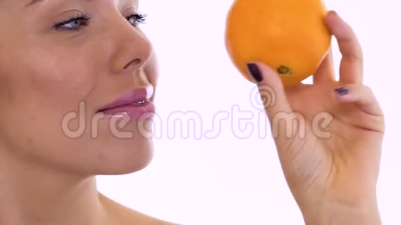 美丽的女人在白色背景下摆着橙色相机视频的预览图
