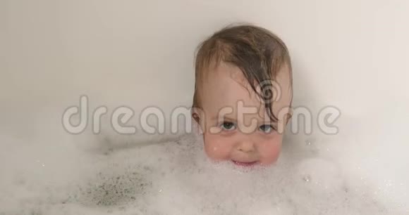 可爱的沐浴男婴头发上有肥皂泡视频的预览图