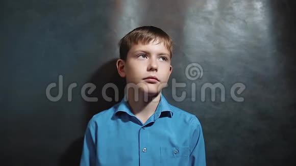 穿蓝色衬衫的小男孩抬起头来年轻的金发欧洲德国男孩思考白人的生活方式视频的预览图