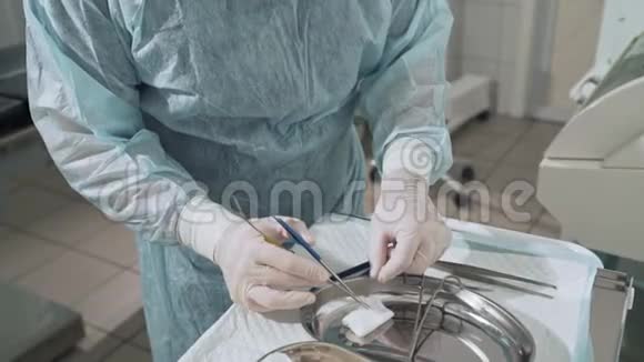 特写镜头外科医生手里拿着一个夹子手里拿着一根手术针背景是一位戴眼镜的医生视频的预览图