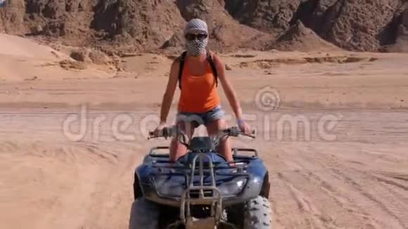一个性感的女孩骑着四轮自行车穿越埃及沙漠以山脉为背景视频的预览图