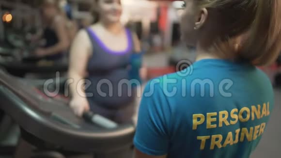 超重的年轻女性要求接受个人训练在健身房锻炼视频的预览图