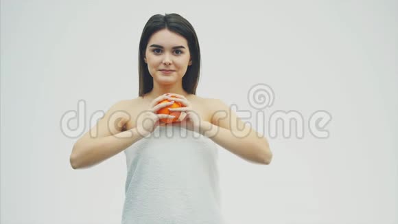 快乐的年轻女孩摆着水果在这期间她看着镜头手里拿着两块橘子视频的预览图
