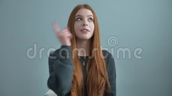 年轻漂亮的红发女孩博客作者向镜头挥手要求订阅频道写一篇视频的预览图