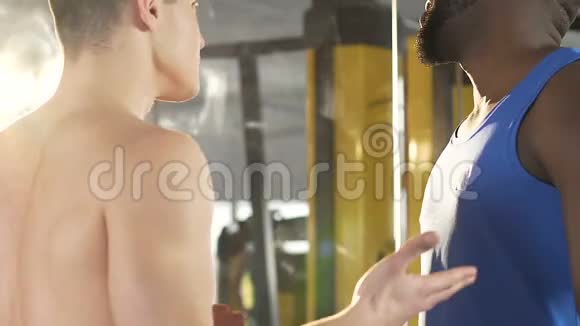 不同国籍的男性健身房成员在健身房争吵互相推搡视频的预览图