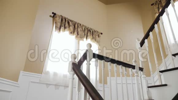 一个白人女人和一个亚洲男人沿着楼梯走拿着纸板箱打扫房间或搬动房子视频的预览图