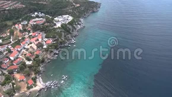 希腊阿吉亚帕拉斯凯维哈尔基迪基地区一个旅游村下带岩石的小海滩鸟瞰图由视频的预览图
