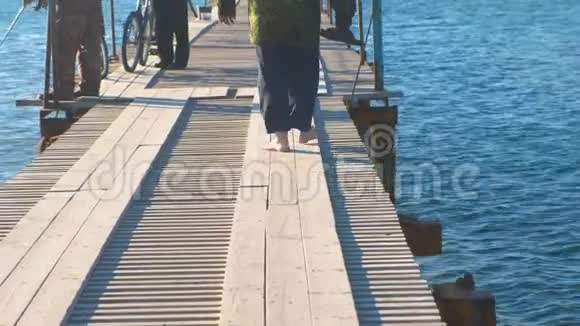 在海滨小镇上的一个木码头上有钓竿的渔民视频的预览图