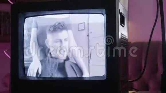 传统的小型黑电视机监控站在后面的歌唱男女视频的预览图