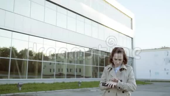 一个玻璃立面背景的女人去打电话视频的预览图