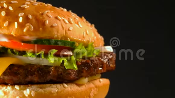含切片洋葱蔬菜融化奶酪生菜酱汁和芝麻的果汁牛肉汉堡孤立视频的预览图