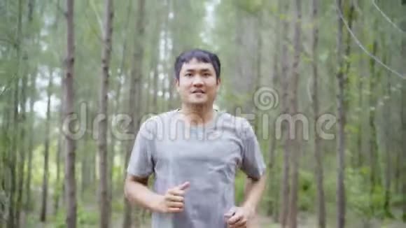 健康英俊年轻运动运动亚洲跑步者穿运动服装在森林小径上跑步和慢跑视频的预览图